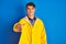 Teenager fisherman boy wearing yellow raincoat over isolated background smiling friendly offering handshake as greeting and