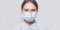 Teenager girl 12-13 years old, face covered with medical mask, close-up portrait, chagrin and serious look, tired and