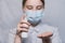Teenager girl of 12-15 years old, medical mask covers face, holds antiseptic spray in hand, disinfects hands from
