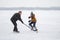 Teenager girl attacking male defender while playing hockey with mature men on a frozen river Dnipro in Ukraine