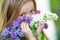 Teenager girl with bouquet of purple and white lilac. Eyes and flowers.