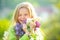 Teenager girl with bouquet of purple and white lilac winking. Funny smiling teenager girl with spring flowers.