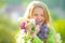 Teenager girl with bouquet of purple and white lilac winking. Funny smiling teenager girl with spring flowers.