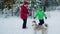 Teenager girl and boy playing with white and gray dog in snowy forest. Children having fun with playful dog in snowy