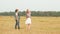 Teenager girl and boy walking on harvesting field on haystack background. Happy girl and boy having fun on countryside