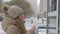 Teenager girl choosing goods in street kiosk on winter walk. Smiling girl buyer holding money wallet front street shop