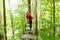 Teenager girl climbing in high rope course or parl