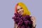 Teenager girl with dyed pink yellow hair holding lilac flowers in hands