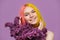 Teenager girl with dyed pink yellow hair holding lilac flowers in hands