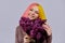 Teenager girl with dyed pink yellow hair holding lilac flowers in hands
