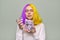 Teenager girl with dyed purple yellow hair holding lilac flowers in hands