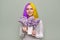 Teenager girl with dyed purple yellow hair holding lilac flowers in hands