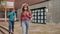 Teenager girl in face mask going home after classes in school with other teens who walking in background.