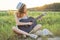 Teenager girl in hat playing the guitar nature background