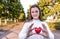 Teenager girl holds red toy heart in her hands, helps gift donation, donate support, care love, emotions tenderness