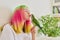 Teenager girl kissing a parrot. Close-up face of woman and green quaker parrot