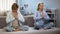 Teenager girl with mother doing namaste yoga gesture during exercises, harmony