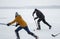 Teenager girl playing hockey with mature men on a frozen river Dnipro in Ukraine