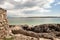 Teenager girl plays on the sand at Gurteen beach, county Galway, Ireland. Warm sunny day. Cloudy sky