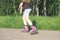 teenager girl practicing in rollerskating in a summer park. partial view. pink inline rollers. teen leisure and sports