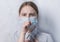 Teenager girl, protective mask, covers her mouth with her hand, cough and sore throat, illness poor health, coronavirus