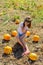 Teenager girl and pumpkin in the vegetable garden. A girl with a pumpkin wearing glasses for Halloween