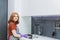 Teenager girl  in purple rubber gloves washes dishes in kitchen