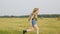 Teenager girl running on harvesting field on hay stack landscape in autumn village. Cheerful girl in jeans short and