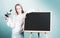 Teenager girl at school. Attractive little girl holding microscope. Portrait of modern teen school girl near blackboard.