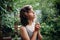 Teenager Girl sniffing chamomile flower in the forest. Natural beauty. Candid moments