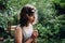 Teenager Girl sniffing chamomile flower in the forest. Natural beauty. Candid moments