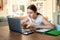 Teenager girl studying online at home looking at laptop at  quarantine isolation period