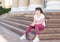 Teenager girl in sunglass is sitting on the steps looking away.