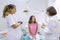 Teenager girl talking with doctors dentists sitting in the dental office. Medicine, dentistry and healthcare concept