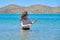 Teenager girl is touching, enjoying sea water in the bay