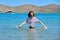 Teenager girl is touching, enjoying sea water in the bay