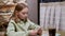 Teenager girl using mobile phone at table with paper menu in cafe. Young girl browsing smartphone on table in cafeteria.