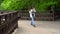 Teenager girl using mobile phone on the wooden bridge. Young teen texting message on smartphone walking. Motion camera