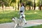 Teenager girl walks the dog on a leash in the park. Owner and husky