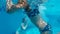 Teenager girls in glasses and swimsuit swimming underwater swimming pool. Girls in underwater goggles having fun in blue