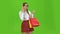 Teenager in glasses is talking on the phone and holding a packet of paper. Green screen