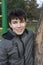 A teenager in a good mood smiles and relaxes after an outdoor workout. On his teeth are braces for leveling teeth. Vertical