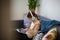 Teenager with headphones is sitting on sofa and study. student girl with tablet in room at home