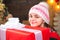 Teenager hold Christmas gift box. Happy Little girl with Christmas gift box. Cute little girl near Christmas tree