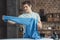 teenager holding blue shirt near ironing board