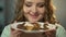 Teenager with hungry eyes admiring plate full of sweets under chocolate dressing
