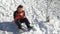 Teenager laying down in the snow making a snowball and eating it