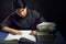 Teenager male writing by books with feather