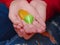 Teenager with manicured nails holding two yellow and green hearts in a palms of her hands. Symbol of love, health and hope and