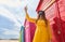 Teenager with a mask and glasses on the beach taking a selfie in the colorful huts. New normal concept